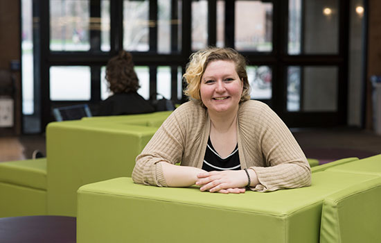 Portrait of Elizabeth Sheffield on a green couch.