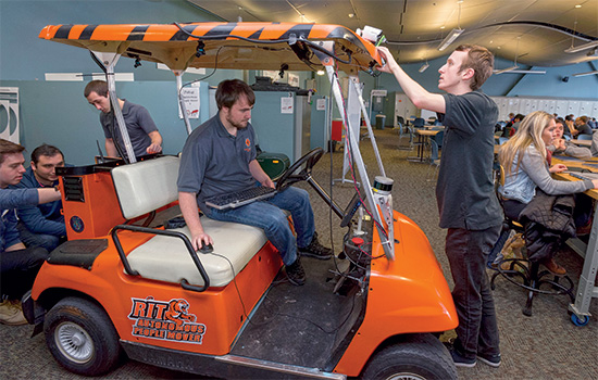 A group of students put the finishing touches on the Autonomous People Mover and check to make sure everything is placed and functioning properly.