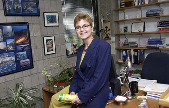 Professor sitting on desk in office