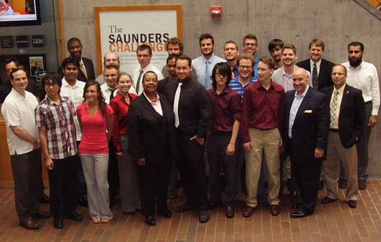 People gathered in front of "The Saunders Challenge sign"