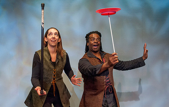 Two people balancing objects on stage 