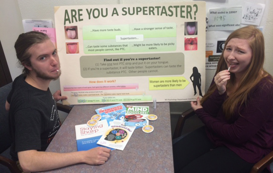 two college students tasting a paper strip.