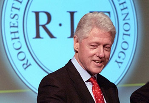 President Clinton in front of RIT logo