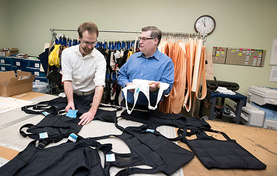 Bradley Dunn and Kurtis Kracke in front of table of their cooling garments.