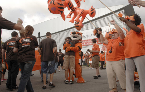 Person hugging tiger mascot in crowd