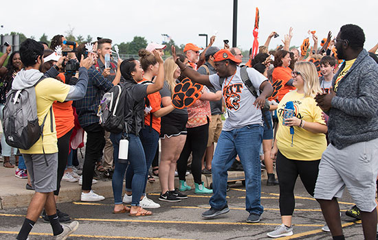 Group of students celebrating in parking lot at convocation.