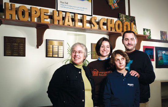 Family Standing in front of "Hope Hall School" sign