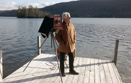 Thomas Shillea standing on a dock with a camera.