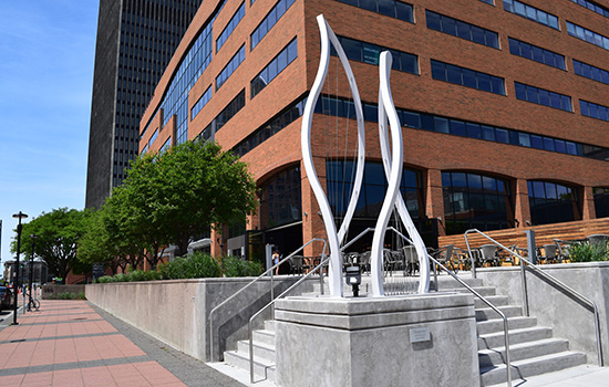 A sculpture sits outside a large building.