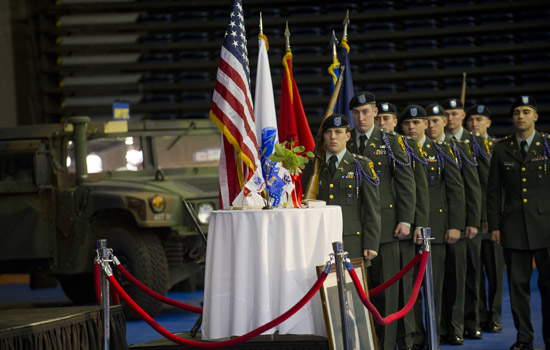 Uniformed people facing decorated table