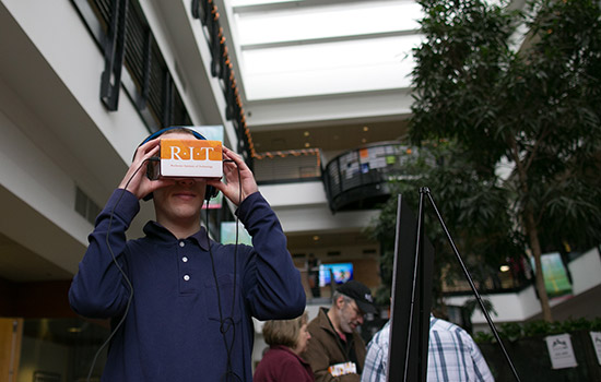 Student holding device over face