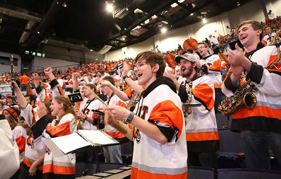 Elise Walsh with RIT Pep band all dressed in RIT Jerseys.