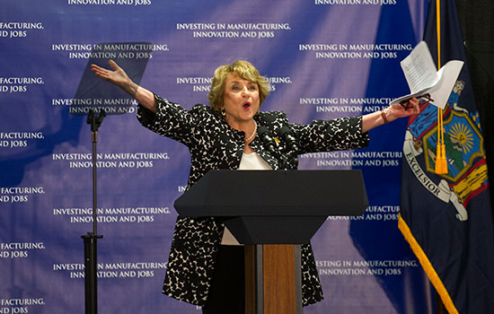 Rep. Louise Slaughter posed with arms out behind a podium.