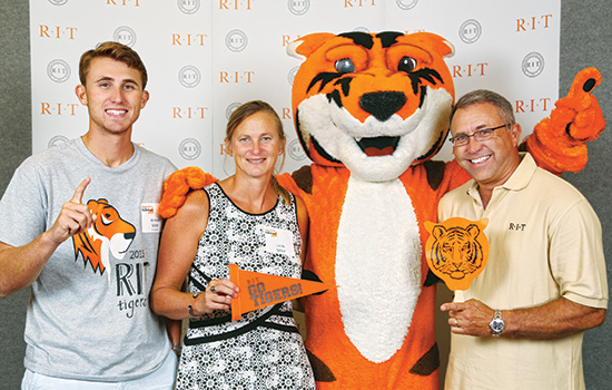 parents and son posing with Tiger mascot.