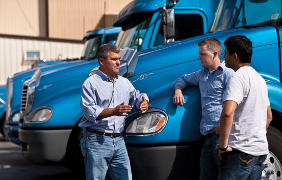 People posing for camera near truck