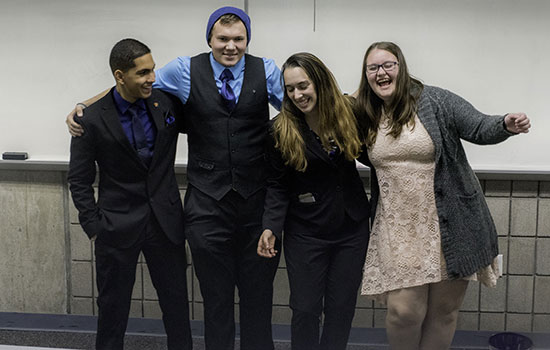 Four members of Alpha Phi Omega Xi Zeta chapter dressed up posing for picture.