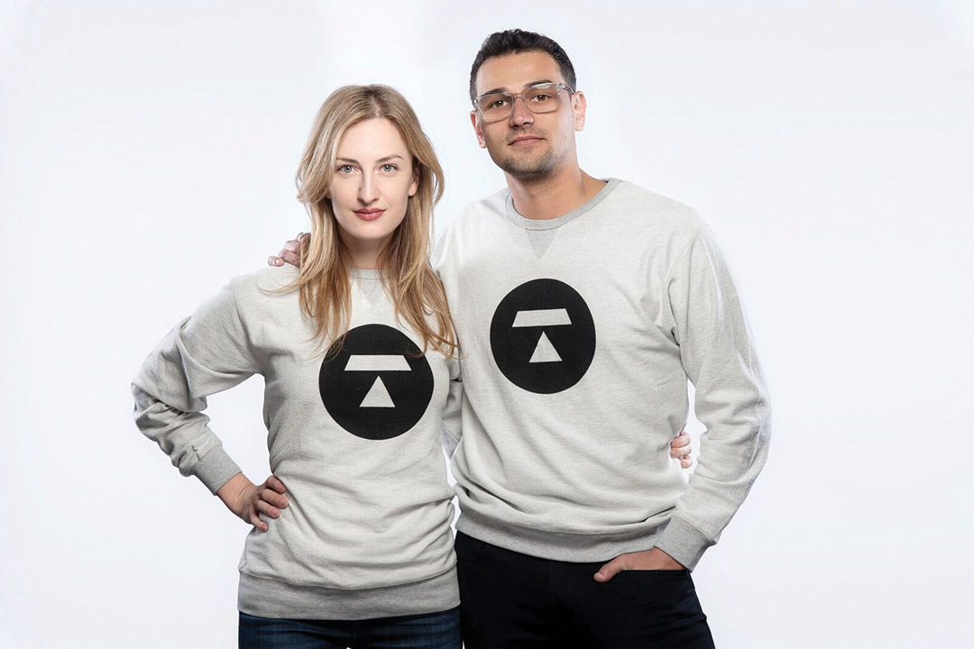 Melanie and Steve Shapiro pose for a photo wearing sweatshirts with the logo of their newest company, Token, on the front of it.