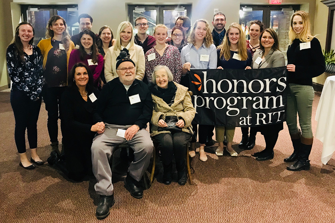 Mike Blain and his wife surrounded by RIT honors program students and Tamra Werner, director of alumni relations celebrating his birthday. 