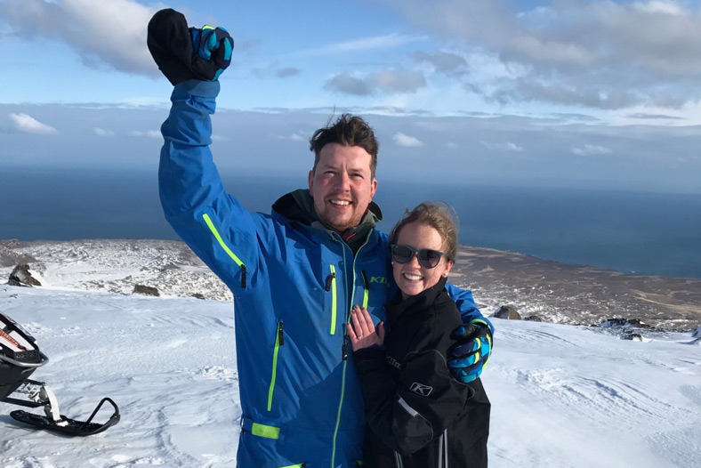 Brynjar and Brianna pose for a photo shortly after getting engaged. Brynjar holds his fist up in their air, seemingly in triumph.