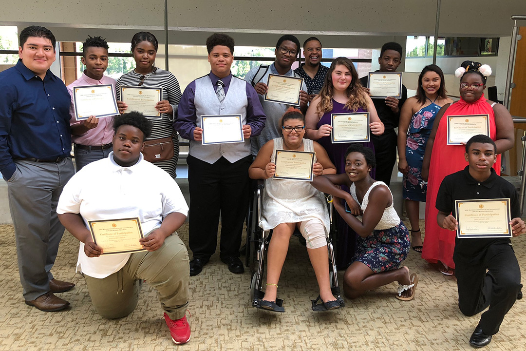 The students who participated in RIT Upward Bound Classic summer program hold up their certificates for completing the program.