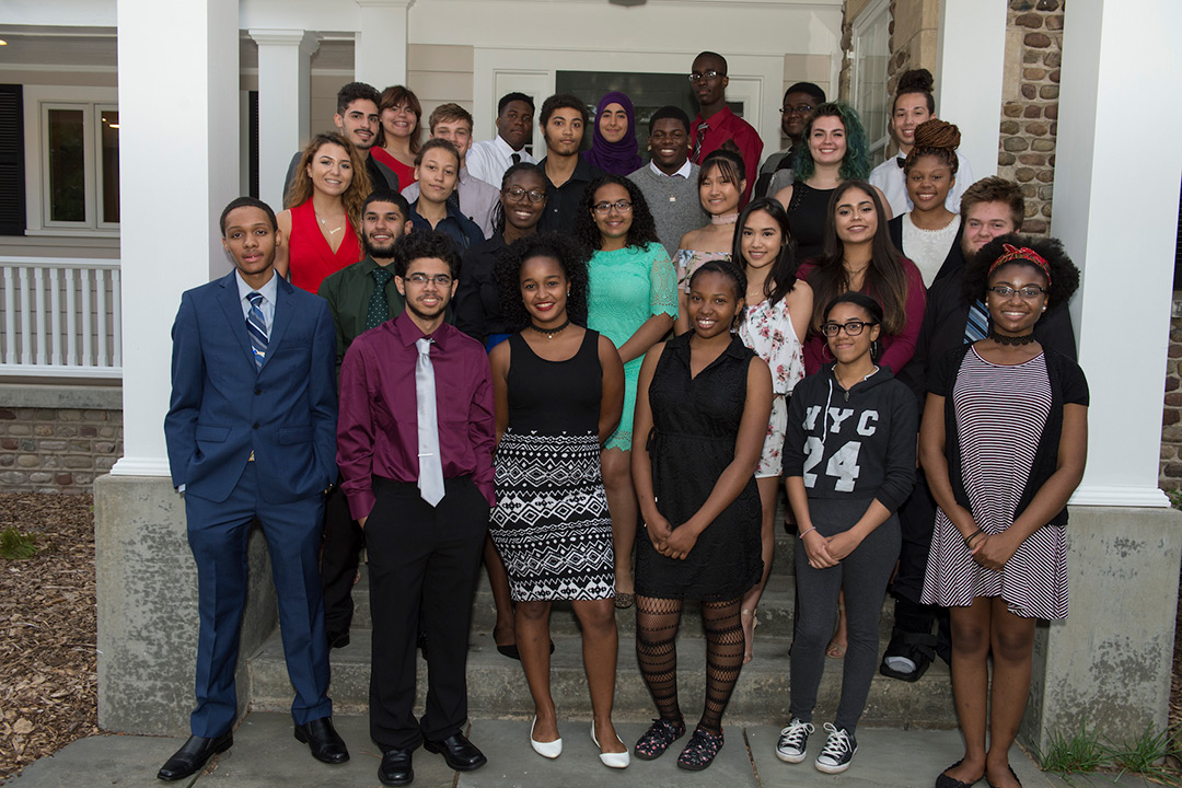 Last year's class of Destler/Johnson scholars pose for a photo on the front steps of a house.