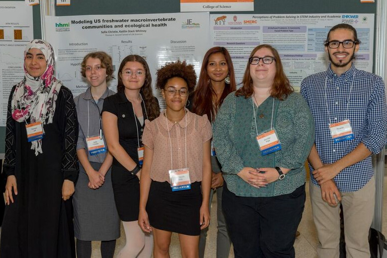 The Inclusive Excellence researchers pose for a photo together in front of their research posters.