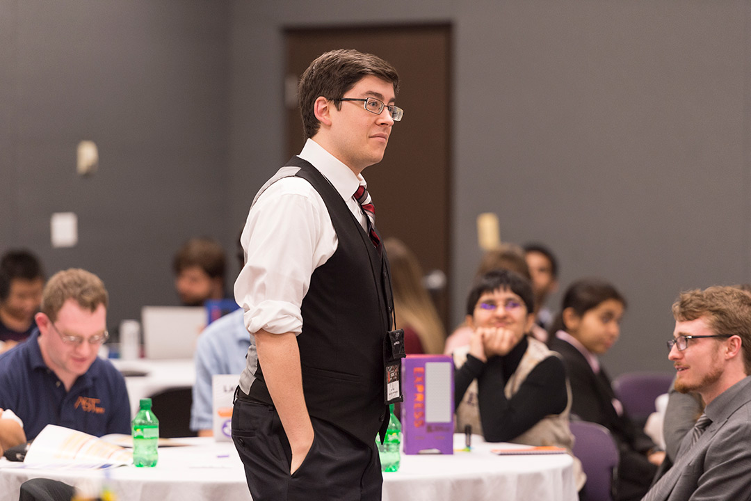 Male student with glasses dressed in suit.