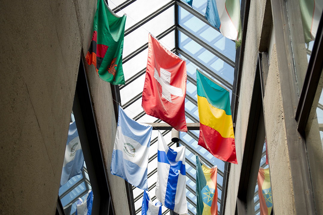 This photo looks up toward the international flags hanging in the Student Alumni Building.