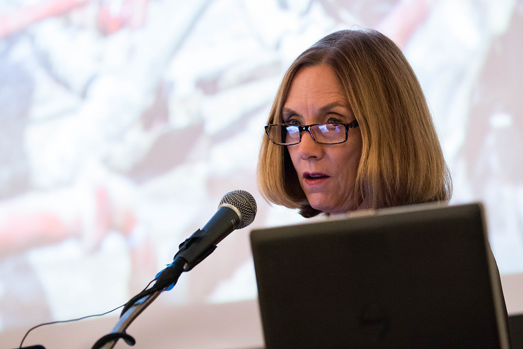 Tana L. Utley stands behind a podium and speaks into a microphone during her keynote speech.