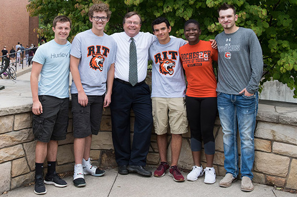 The five Magquire Scholars stand for a photo outside with RIT/NTID President Gerry Buckley.