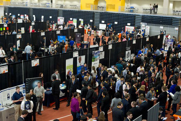 An aerial view of a crowd of students waiting in lines and interacting with potential employers at the career fair.