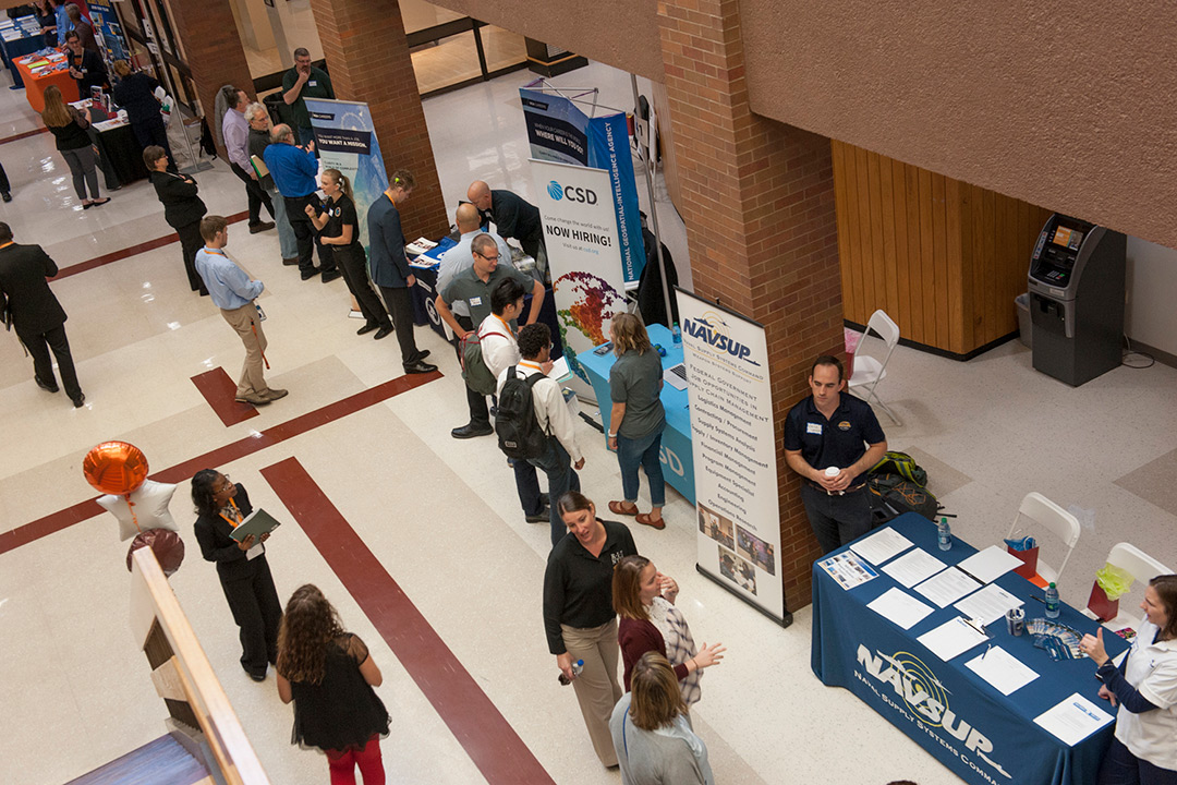 An aerial view of students interacting with employer booths at the career fair.