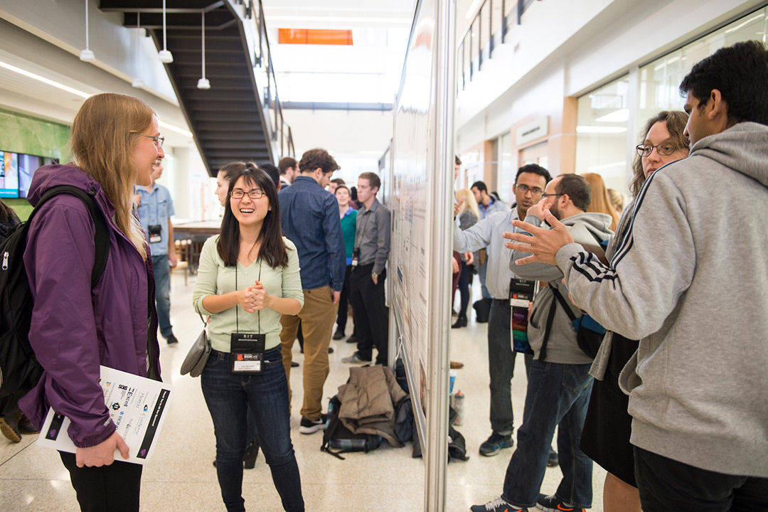 groups of students present posters to visitors