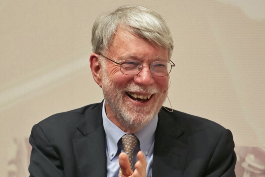 Smiling man with glasses and beard, wearing a suit