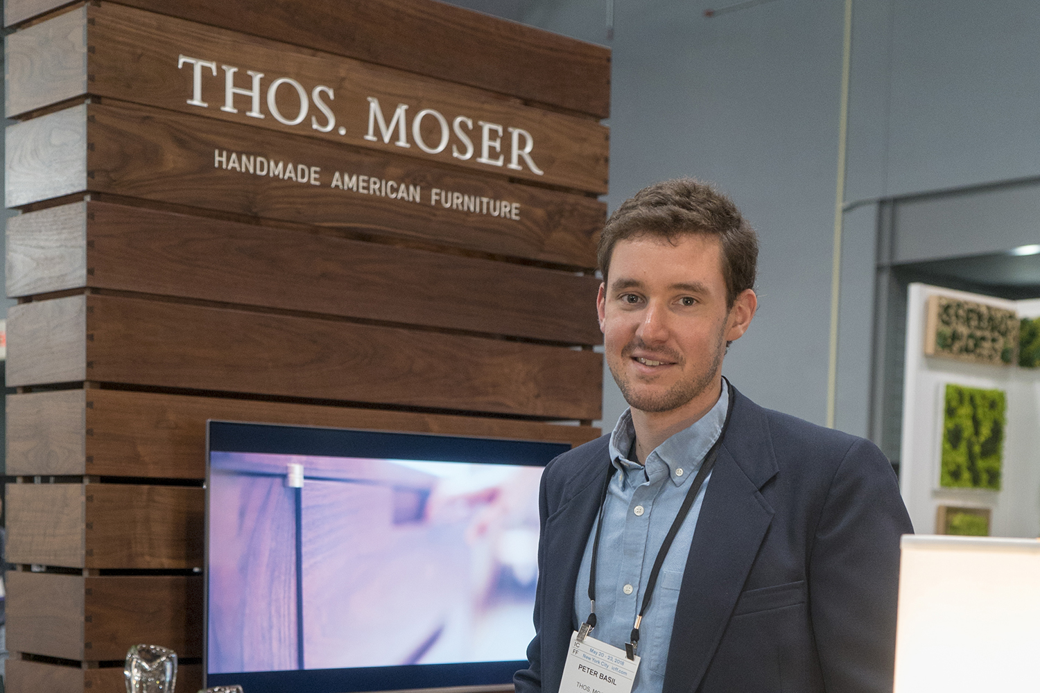 Peter Basil poses in front of a Thos. Moser exhibit at ICFF 2018.