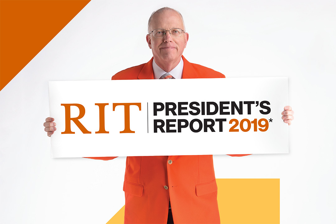 RIT president in orange suit coat hold banner that readers: RIT President's Report 2019