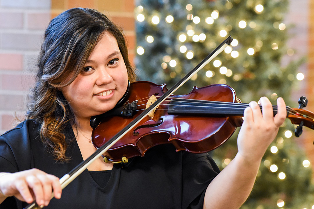 student poses with violin