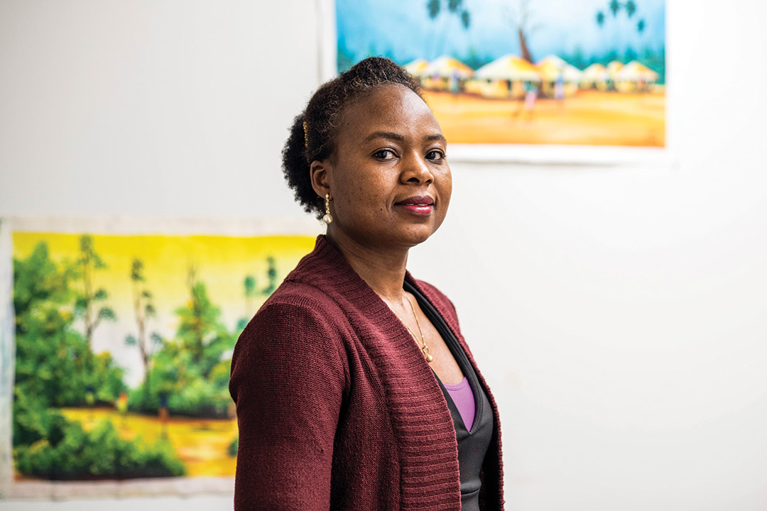 Woman stands in front of artwork.