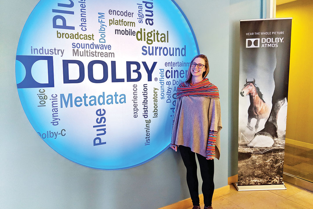 Woman standing next to Dolby sign