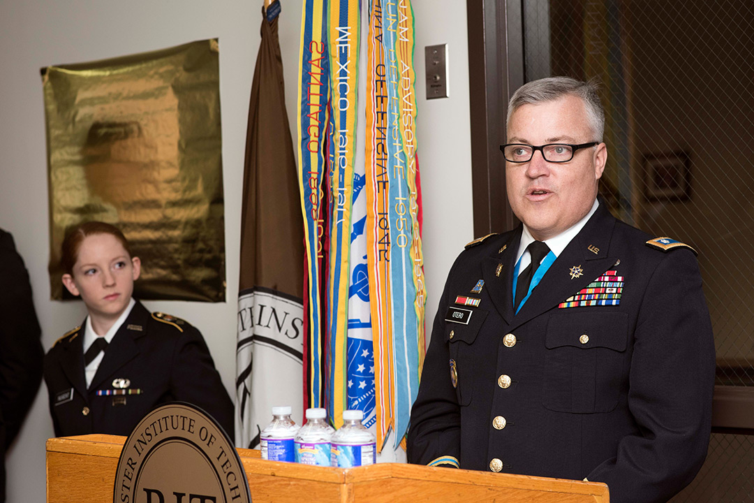 Man in U.S. Army Class A uniform speaks at podium