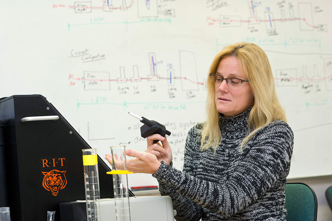 Researcher holds device that measure cigarette smoke