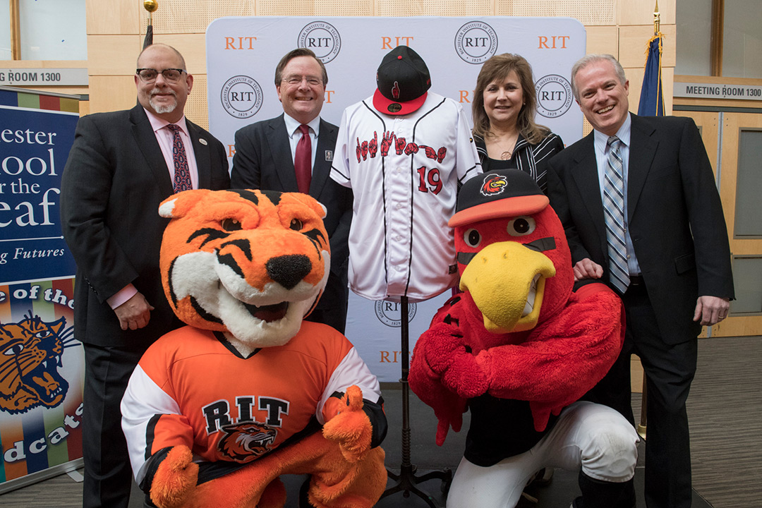 Four people post with Tiger mascot and cardinal mascot