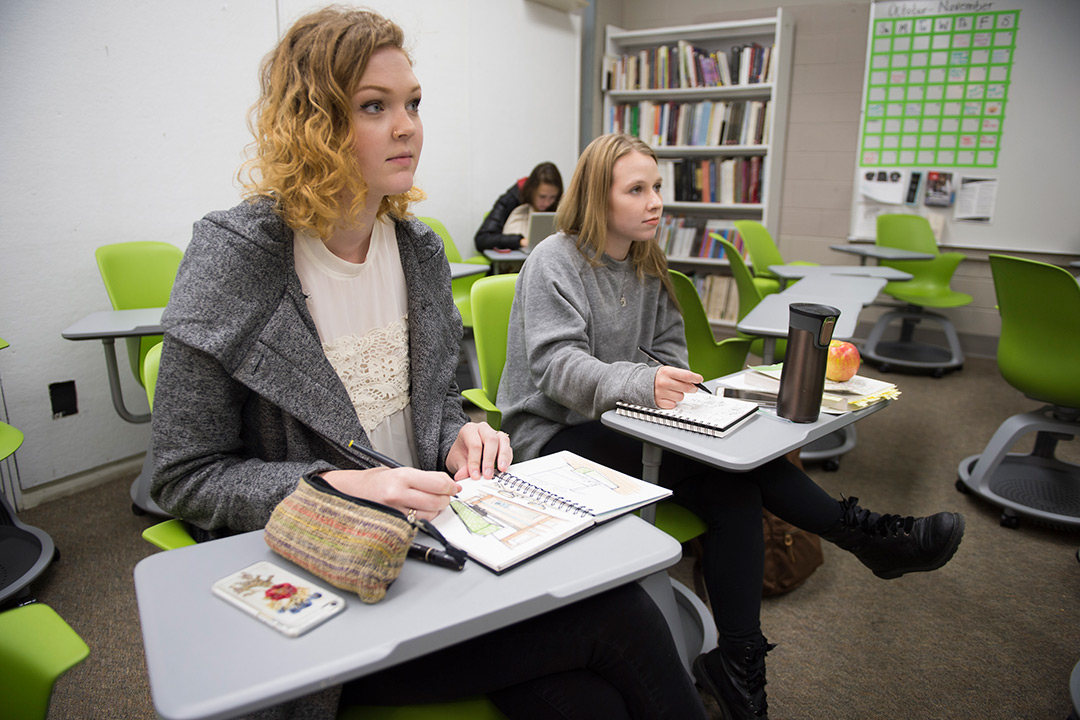 Two students sit at desks