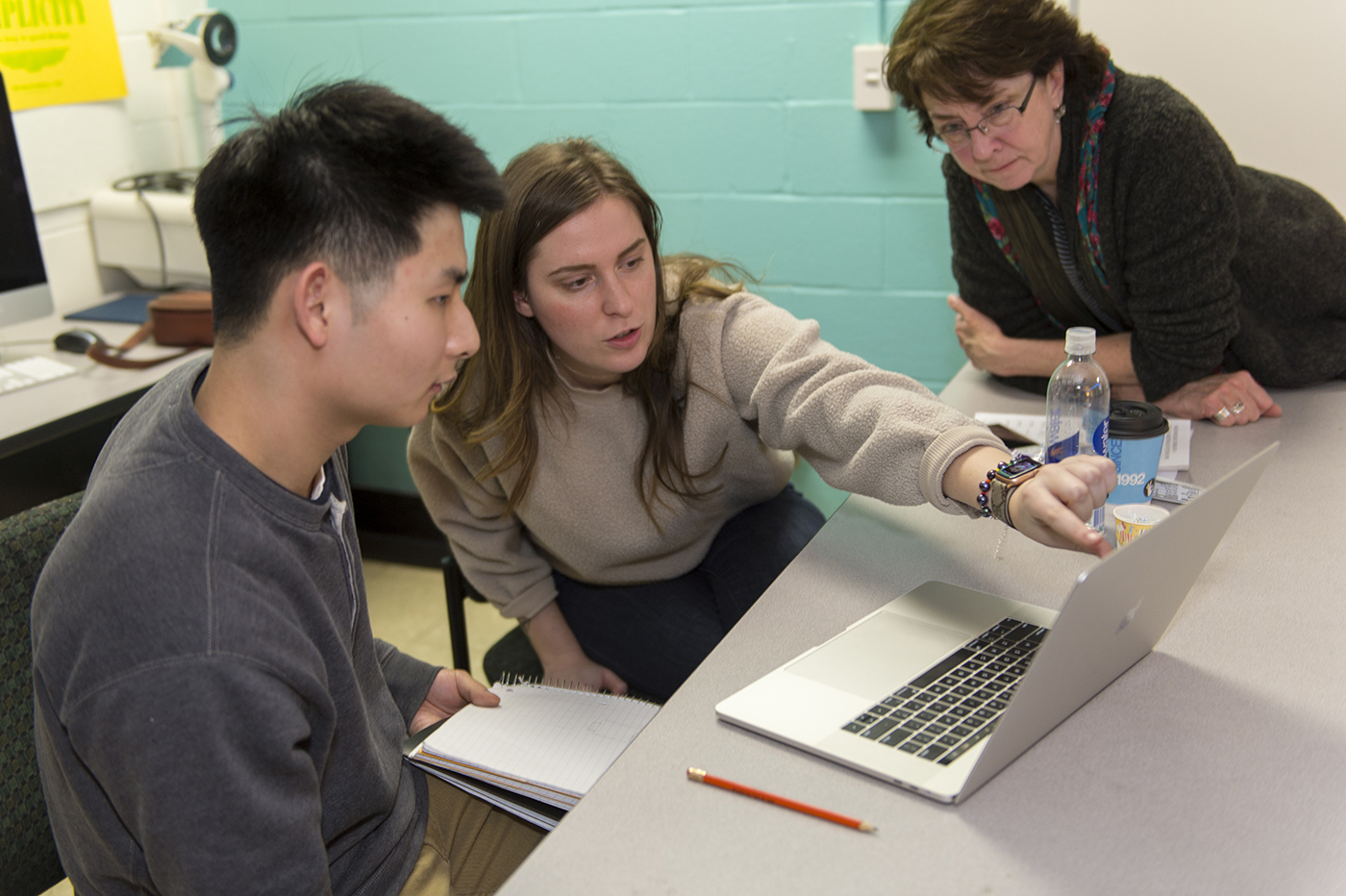 A visiting artist works with a student