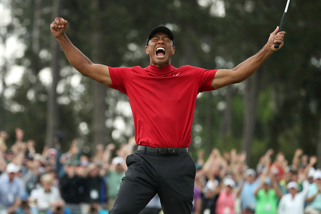 Tiger Woods raises his arms in victory.