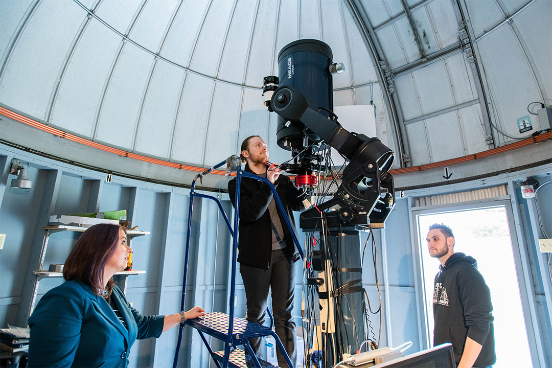 Students work on a telescope.