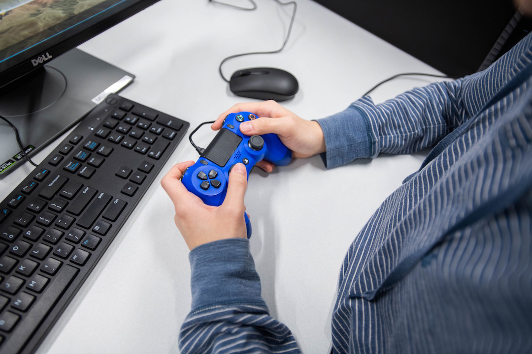 Person holding blue game controller.