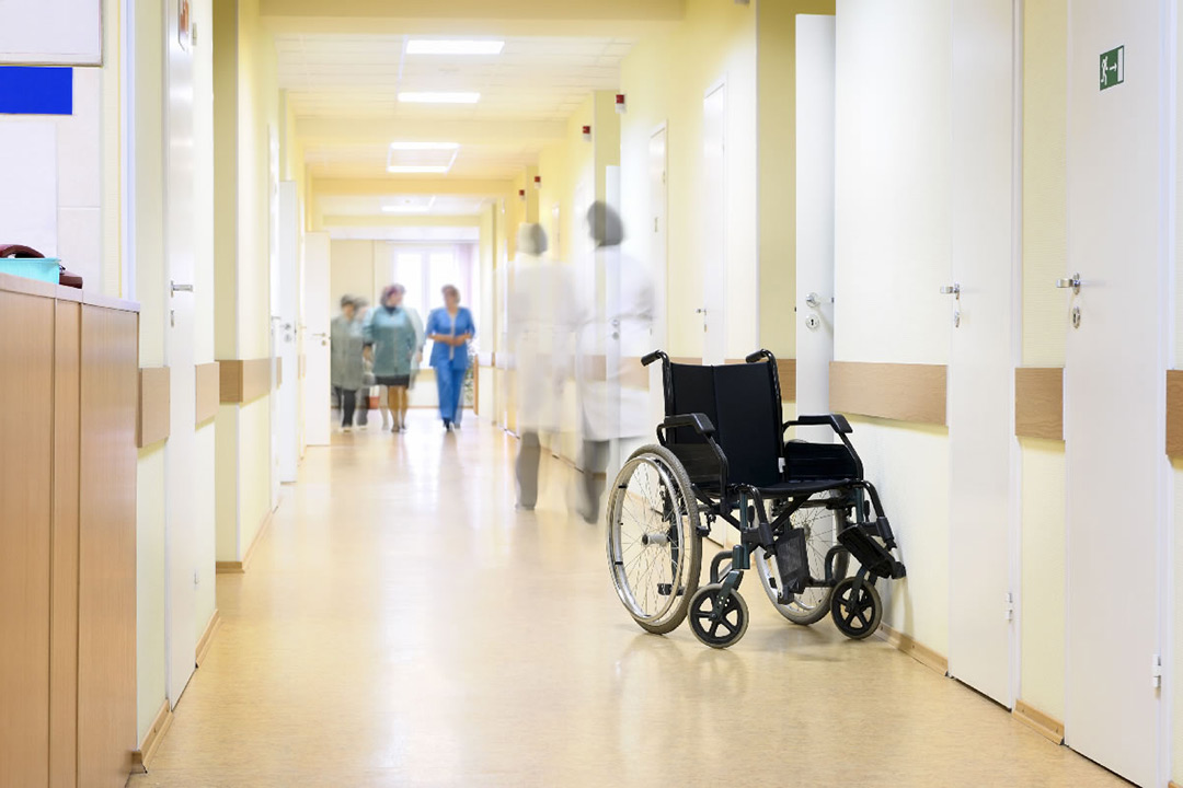 Hallway in hospital with empty wheelchair.