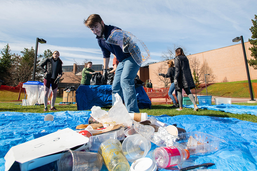 Student sorts pile of recyclables.