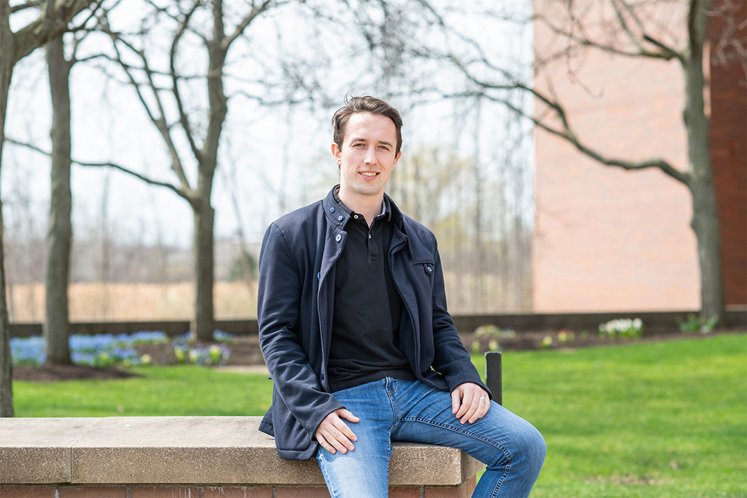 Student sits on brick wall.